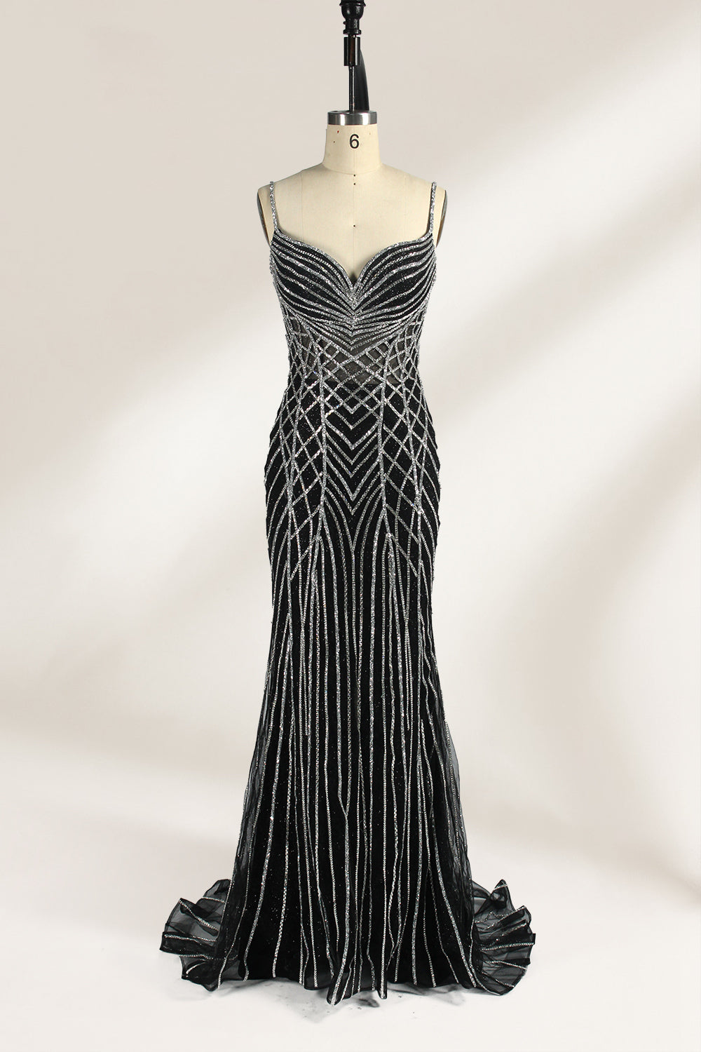 Set against a light background, a mannequin presents a black tulle gown with silver - toned beaded embellishments. Thin straps, a sweetheart neckline, and a mermaid - style skirt complete the look. The geometric bead patterns add a touch of glamour, ideal for proms or formal events where the beaded artistry stands out.1