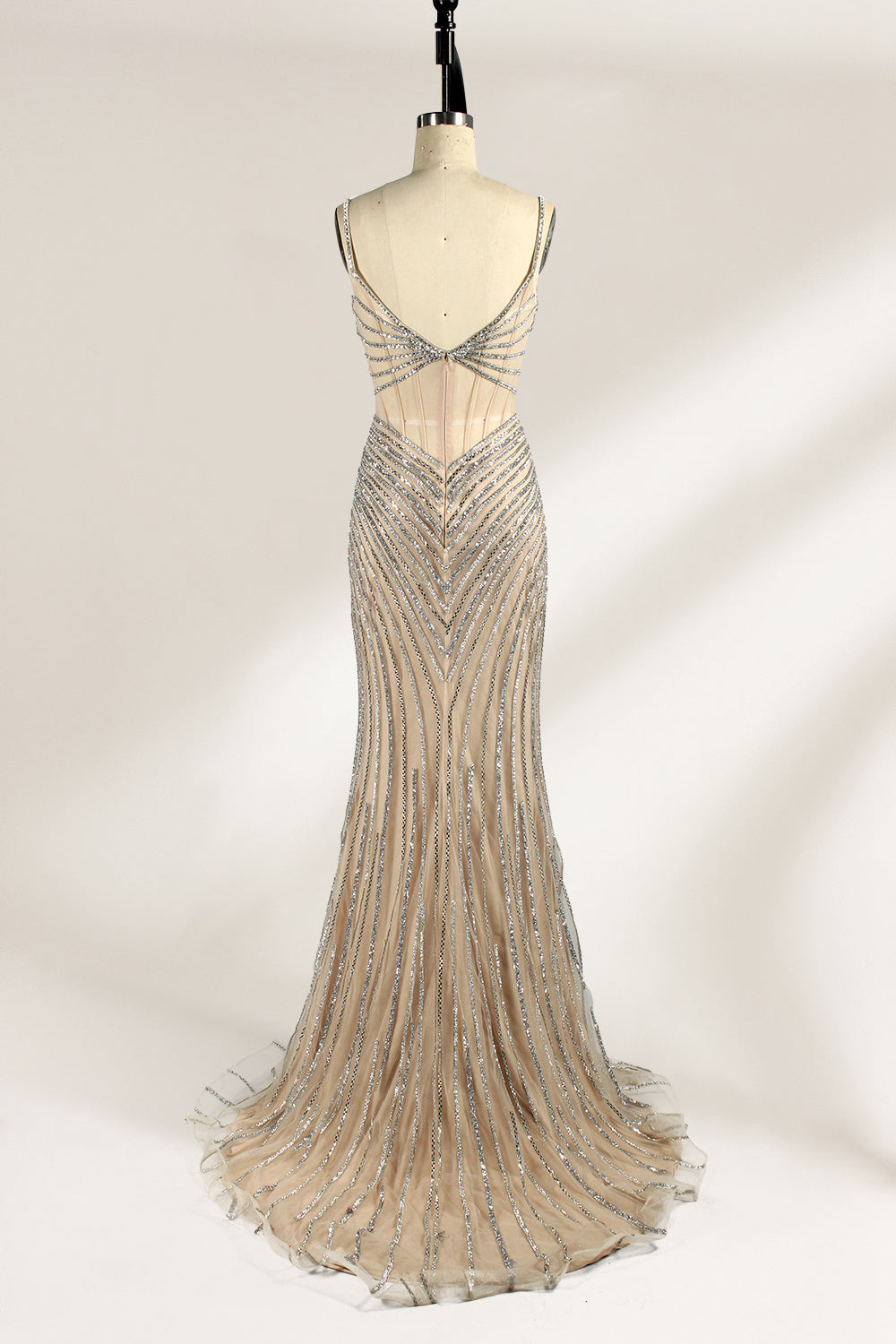 A mannequin numbered “6” displays a black tulle gown against a light backdrop. It features thin straps, a deep V - neckline, and a mermaid silhouette. The intricate silver bead patterns, sheer bodice with vertical accents, and high side slit add glamour, perfect for formal galas.2