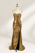 A golden strapless evening gown is displayed on a mannequin. The bodice is adorned with intricate beadwork, and the skirt, made of a shiny metallic fabric, features a high side slit and a small train, creating a glamorous and elegant look, perfect for formal events.1