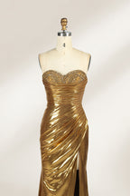 A golden strapless evening gown is displayed on a mannequin. The bodice is adorned with intricate beadwork, and the skirt, made of a shiny metallic fabric, features a high side slit and a small train, creating a glamorous and elegant look, perfect for formal events.4