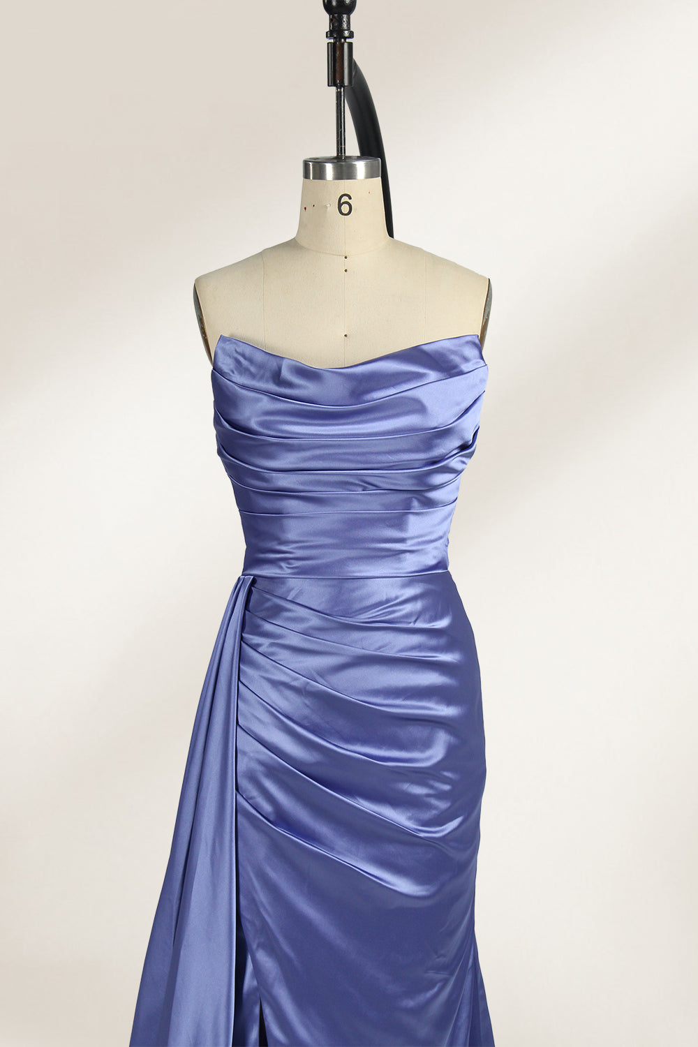 A strapless, lavender - blue satin evening gown is displayed on a mannequin. It features a draped bodice, ruched detailing on the skirt, a high side slit, and a flowing train, creating an elegant and graceful look, suitable for formal occasions.3