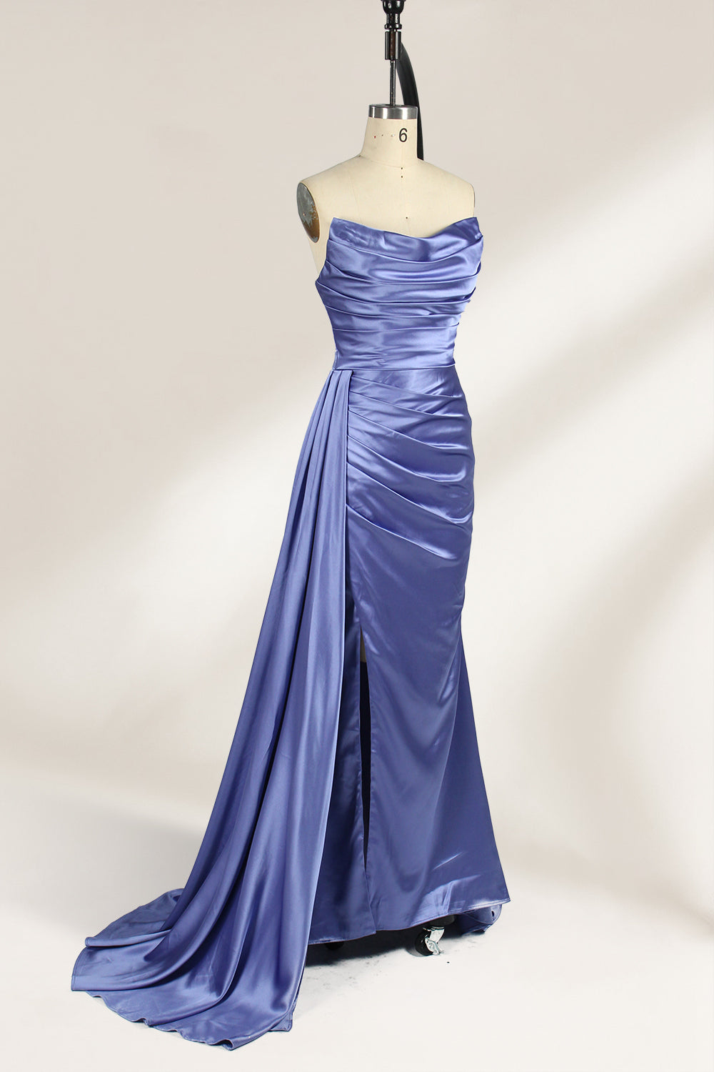 A strapless, lavender - blue satin evening gown is displayed on a mannequin. It features a draped bodice, ruched detailing on the skirt, a high side slit, and a flowing train, creating an elegant and graceful look, suitable for formal occasions.1