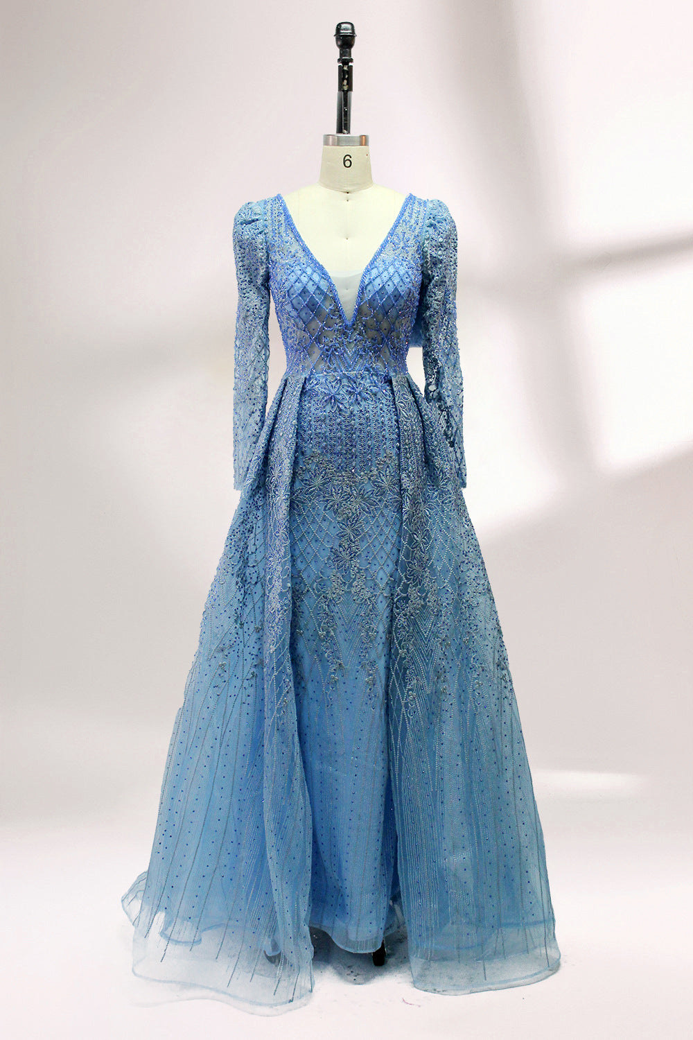 Illuminated softly, a mannequin showcases a light - gray evening gown. With a deep V - neckline, long puffed sleeves, and elaborate bead and lace embroidery, the gown exudes an air of luxury and sophistication, making it an excellent choice for formal galas and upscale events.3