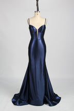 Photograph of a slender, fair-skinned woman with dark hair in an elegant updo, wearing a stunning, floor-length, light blue satin gown with a plunging neckline and thin spaghetti straps. The dress features a fitted bodice and a flowing skirt. She stands against a plain, light gray background, with soft lighting emphasizing the gown's sheen.8