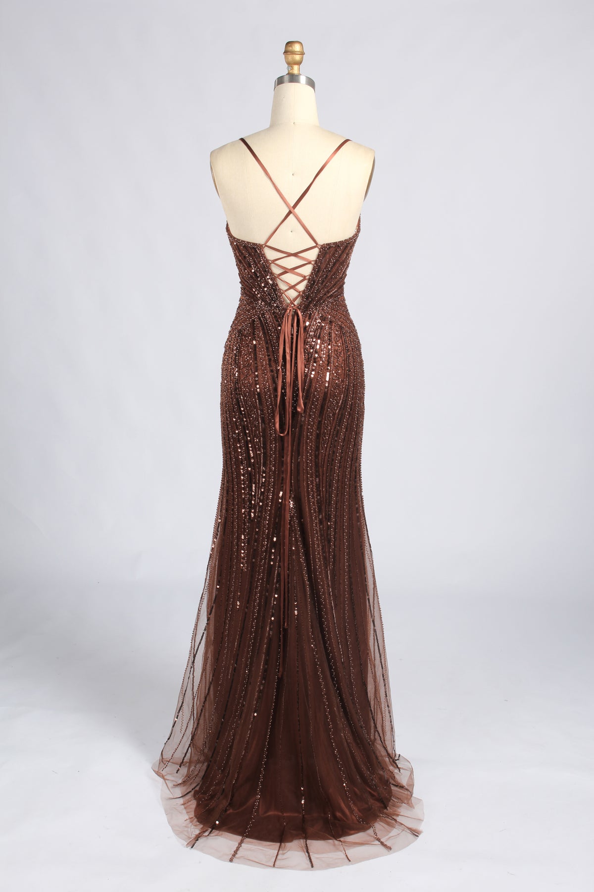 Back of the brown beaded gown with crisscross straps, lace-up detail, and a flared hem