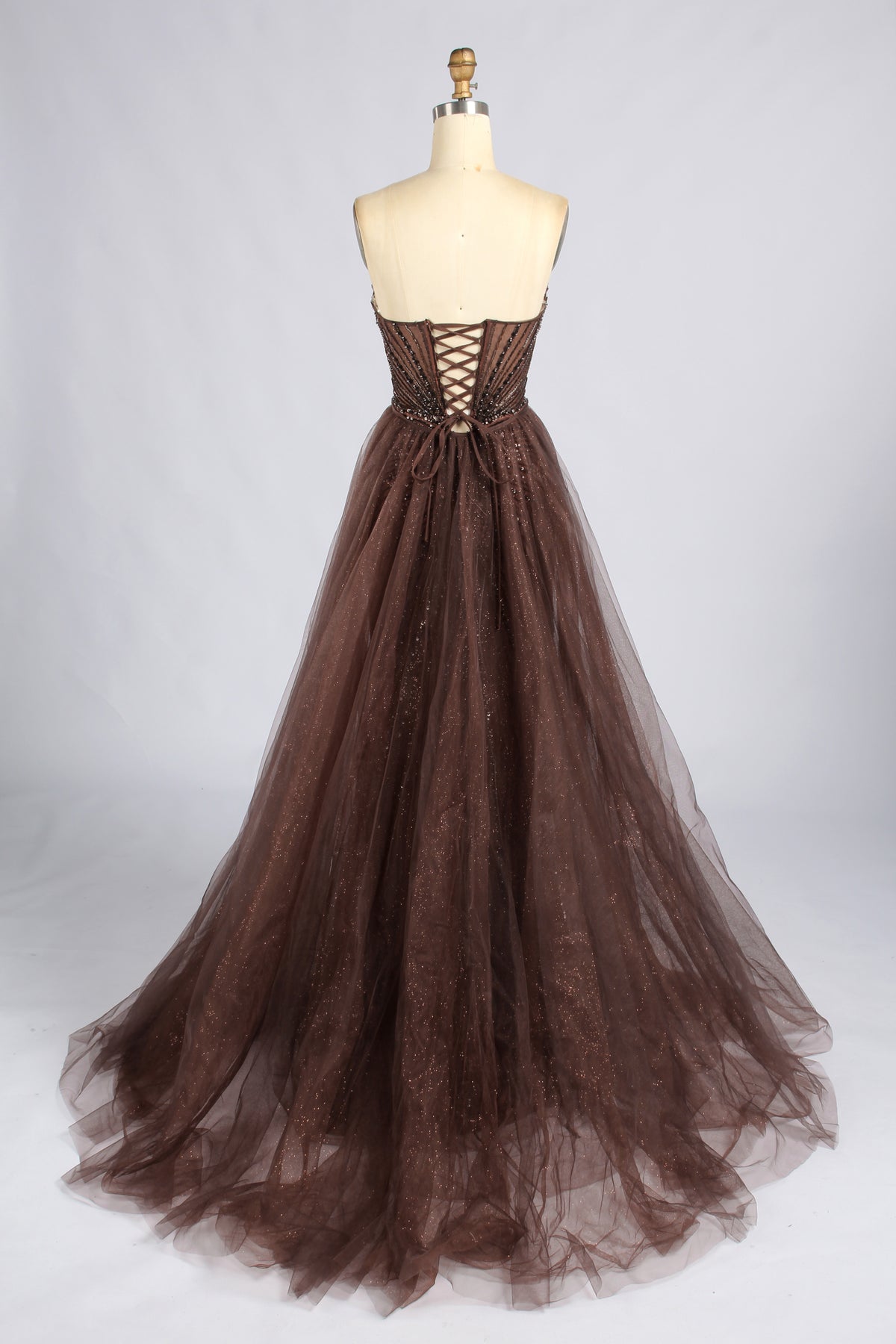 Back of the brown strapless prom dress, showing a lace-up bodice and full tulle skirt.