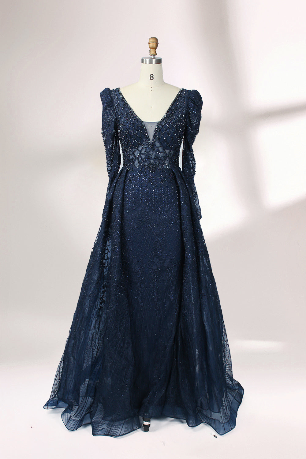 Illuminated softly, a mannequin showcases a light - gray evening gown. With a deep V - neckline, long puffed sleeves, and elaborate bead and lace embroidery, the gown exudes an air of luxury and sophistication, making it an excellent choice for formal galas and upscale events.4