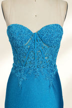 Photograph of a mannequin dressed in a strapless, floor-length, vibrant blue evening gown. The gown features intricate lace detailing across the bodice, with a fitted, corset-style silhouette. The skirt has a high slit on the right side, revealing black high heels underneath. The background is a plain, light beige, emphasizing the gown's shimmering texture and elegant design. The mannequin stands on a wooden base, labeled "4" on its neck.04