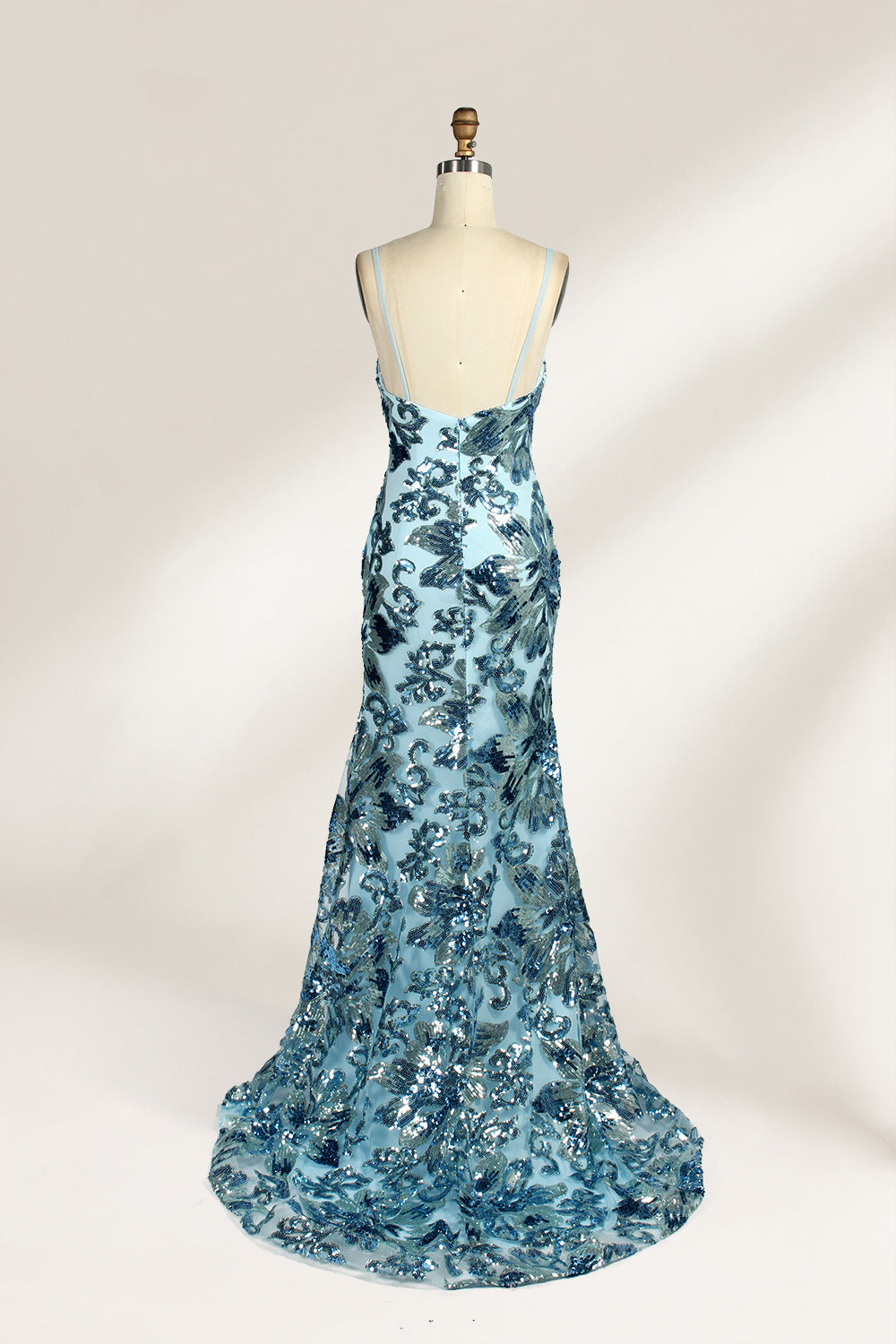 Set against a light background, a mannequin presents a light - blue tulle gown adorned with intricate floral sequin patterns. It has thin spaghetti straps, a sweetheart neckline, and a mermaid - shaped skirt with a high side slit. The shimmering sequins and delicate design create a glamorous look, ideal for proms or formal evening events.2