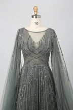 Beaded A-line gown with V neckline, sheer cape sleeves, and sparkling dark metallic beadwork
