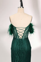 A mannequin displays a dark green strapless evening gown. It has feather - trimmed cups and a sequined, form - fitting skirt that reaches the floor, with a side slit. The intricate design and shimmering texture make it elegant for formal events.05
