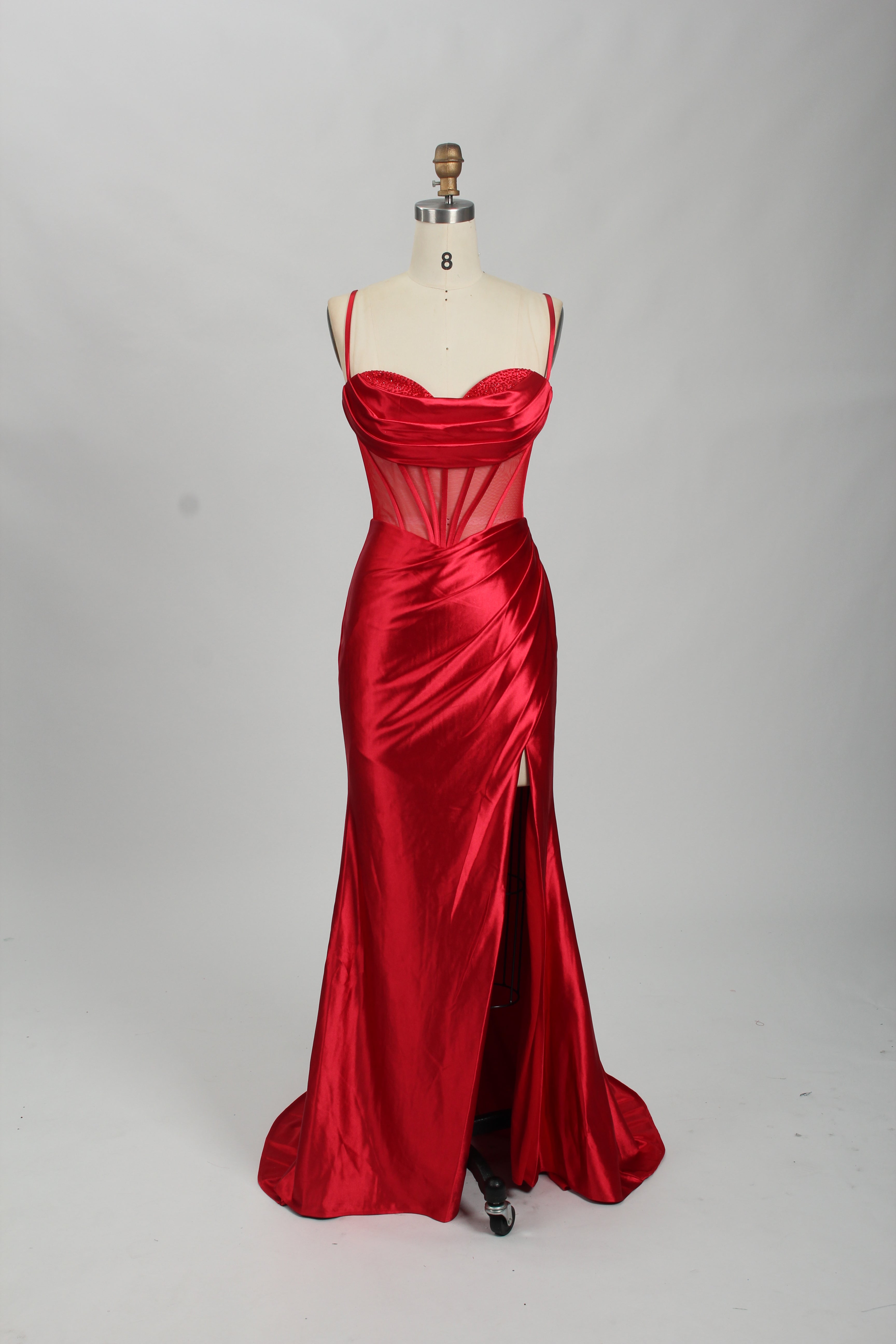 Red satin prom dress with sheer corset bodice, side slit & drape. Luxe, eye-catching design—perfect for bulk orders in premium formal collections.
