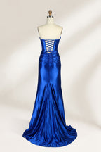 A mannequin showcases a strapless, blush - pink satin gown against a light backdrop. It features a ruched bodice with a draped neckline and a twisted detail at the waist, along with a mermaid silhouette and a side slit. The smooth satin fabric exudes elegance, perfect for formal events like galas.2