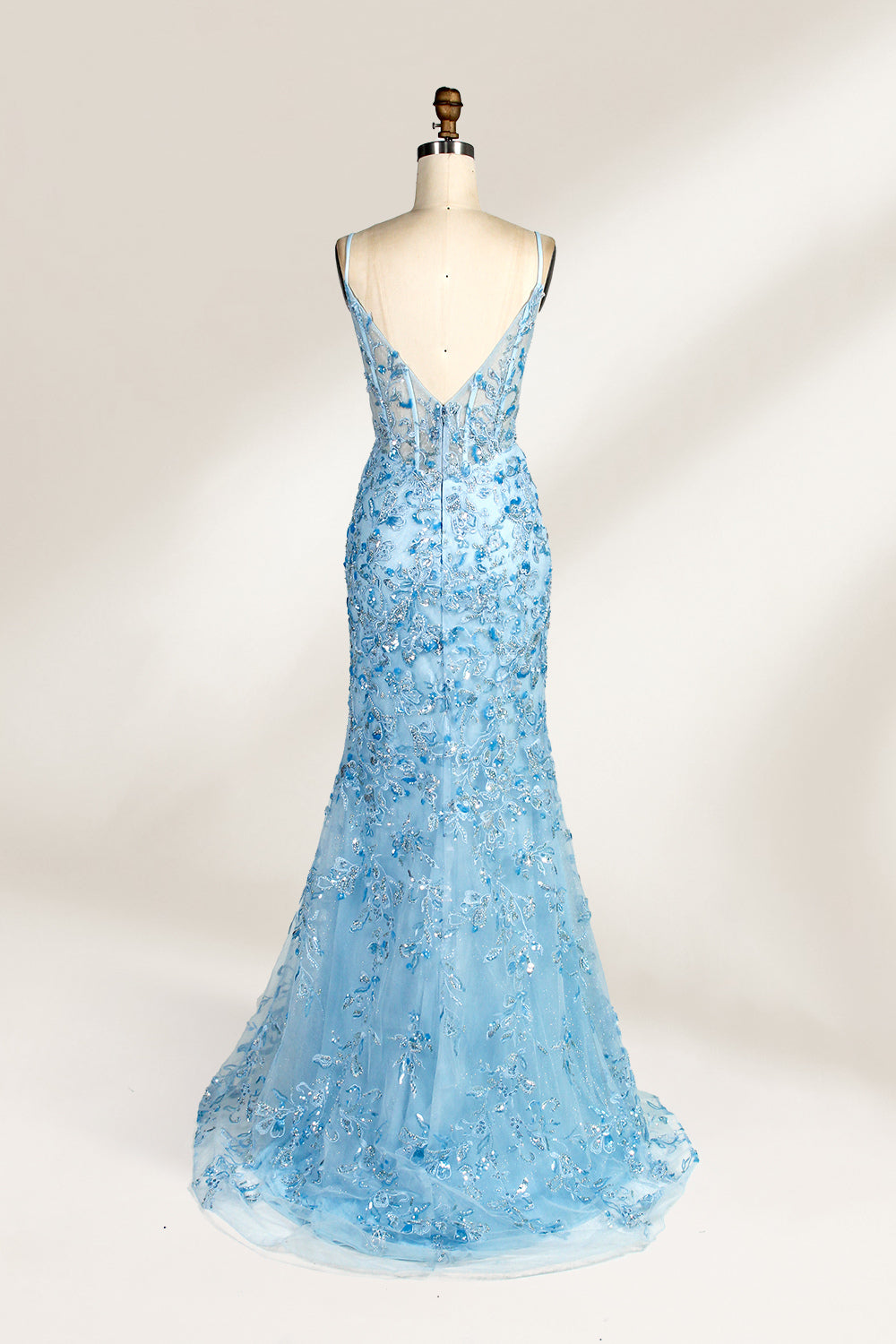 A mannequin showcases a light - blue tulle gown. It has thin straps, a V - neck, floral embroidery, and a high side slit. The intricate design, with sheer bodice details, suits formal events like galas or proms, radiating elegance and charm.2