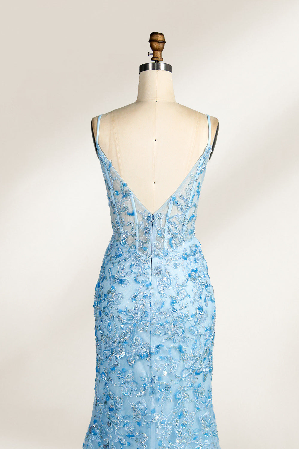 A mannequin showcases a light - blue tulle gown. It has thin straps, a V - neck, floral embroidery, and a high side slit. The intricate design, with sheer bodice details, suits formal events like galas or proms, radiating elegance and charm.6