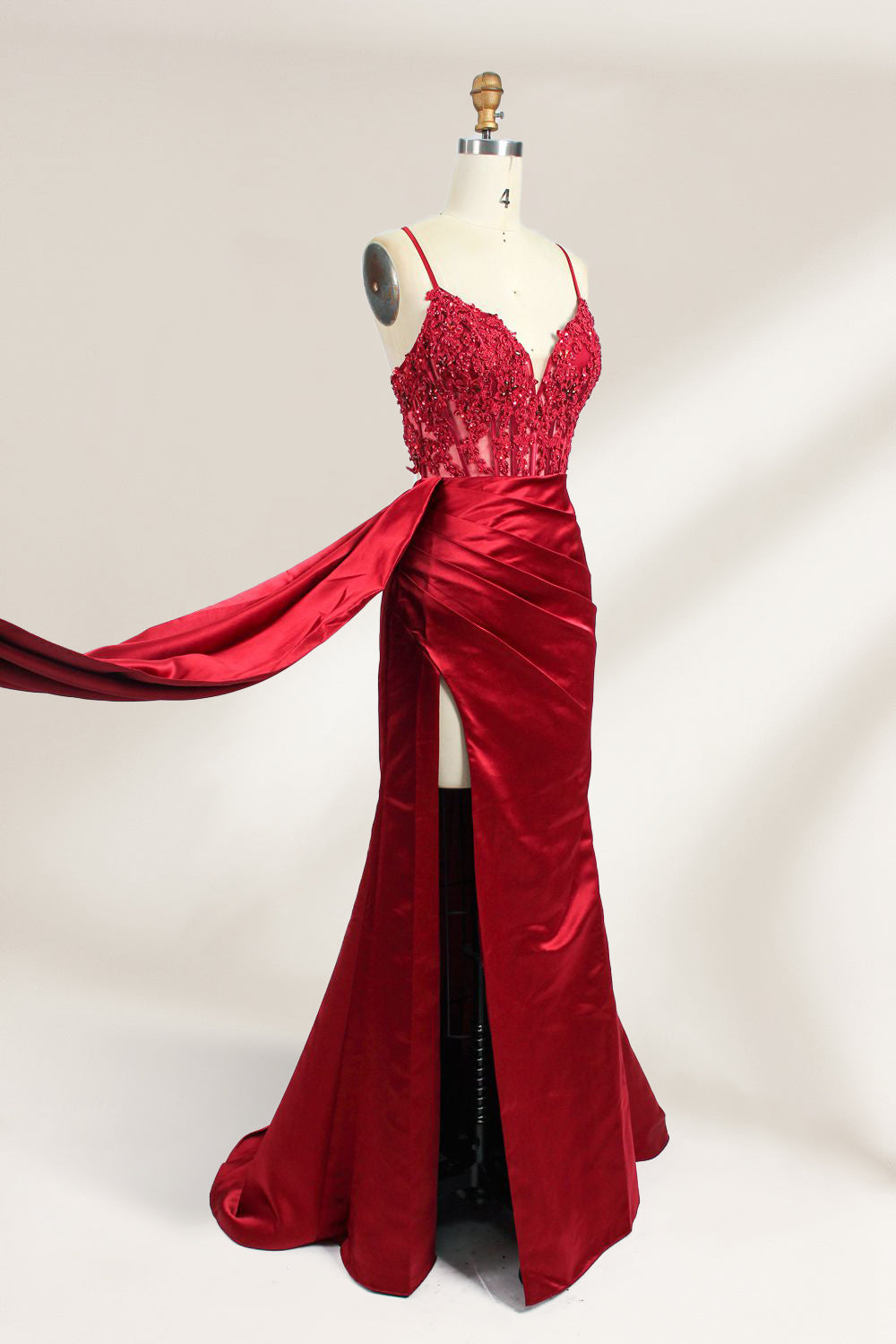 A mannequin showcases a royal - blue gown with thin straps. The bodice features intricate bead embroidery and sheer panels, while the skirt has a ruched design and a high side slit. The satin fabric and elegant details make it perfect for formal events like proms or galas, exuding sophistication.4