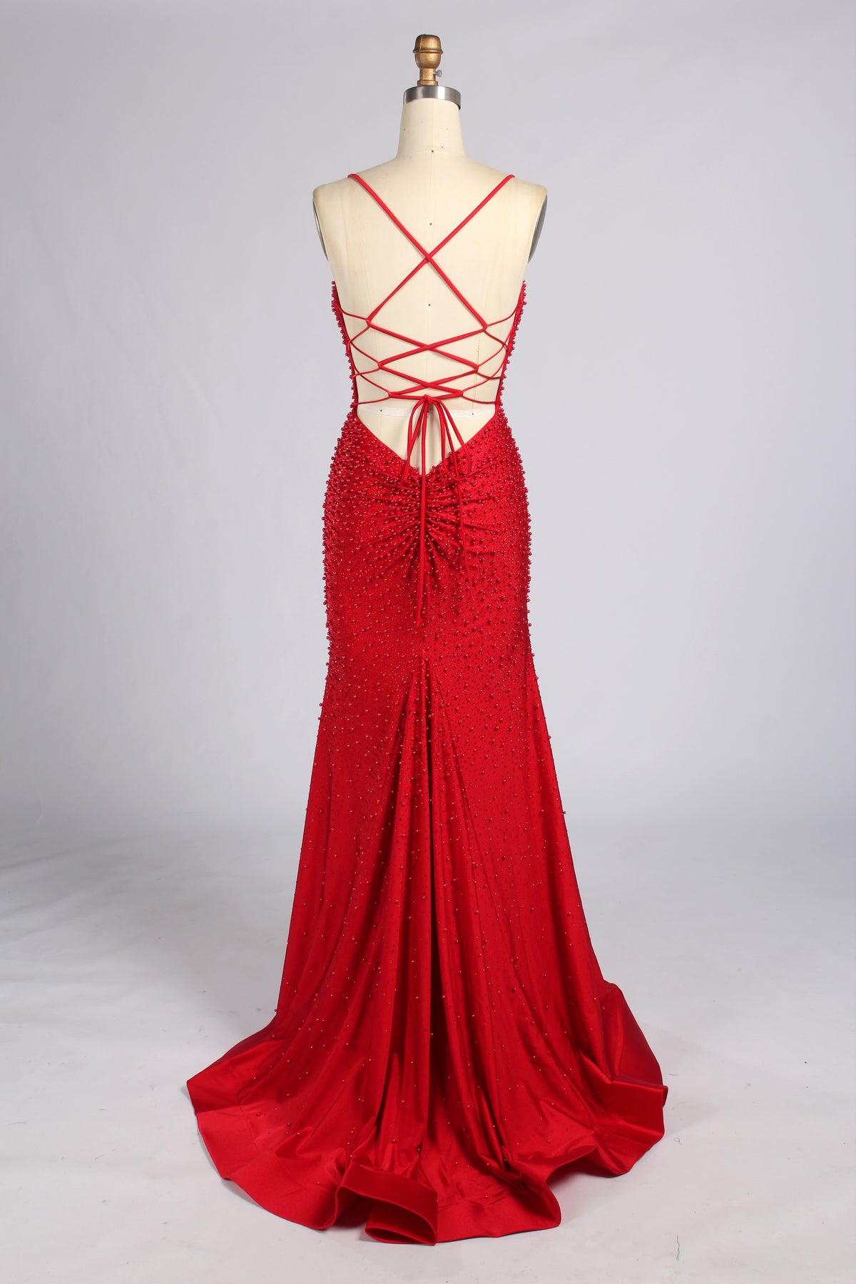 Red beaded mermaid prom dress with spaghetti straps; open back crisscross detail