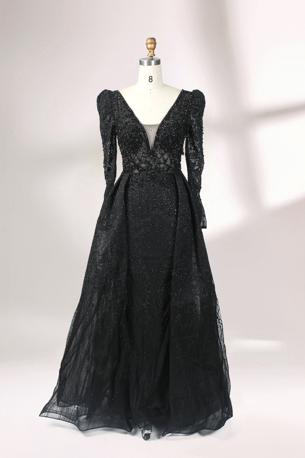 Illuminated softly, a mannequin showcases a light - gray evening gown. With a deep V - neckline, long puffed sleeves, and elaborate bead and lace embroidery, the gown exudes an air of luxury and sophistication, making it an excellent choice for formal galas and upscale events.6