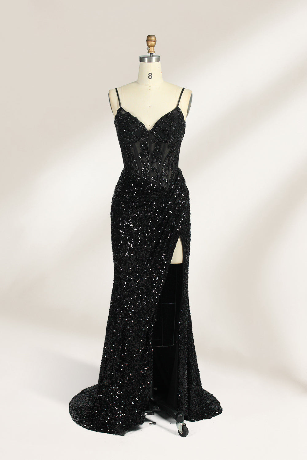 Set against a light background, a mannequin presents a blue gown adorned with sequins. It has thin straps, a deep V - neckline, and a mermaid - shaped skirt with a high side slit. The intricate sequin patterns and sheer bodice with embroidery add glamour, ideal for proms or formal dinners.1