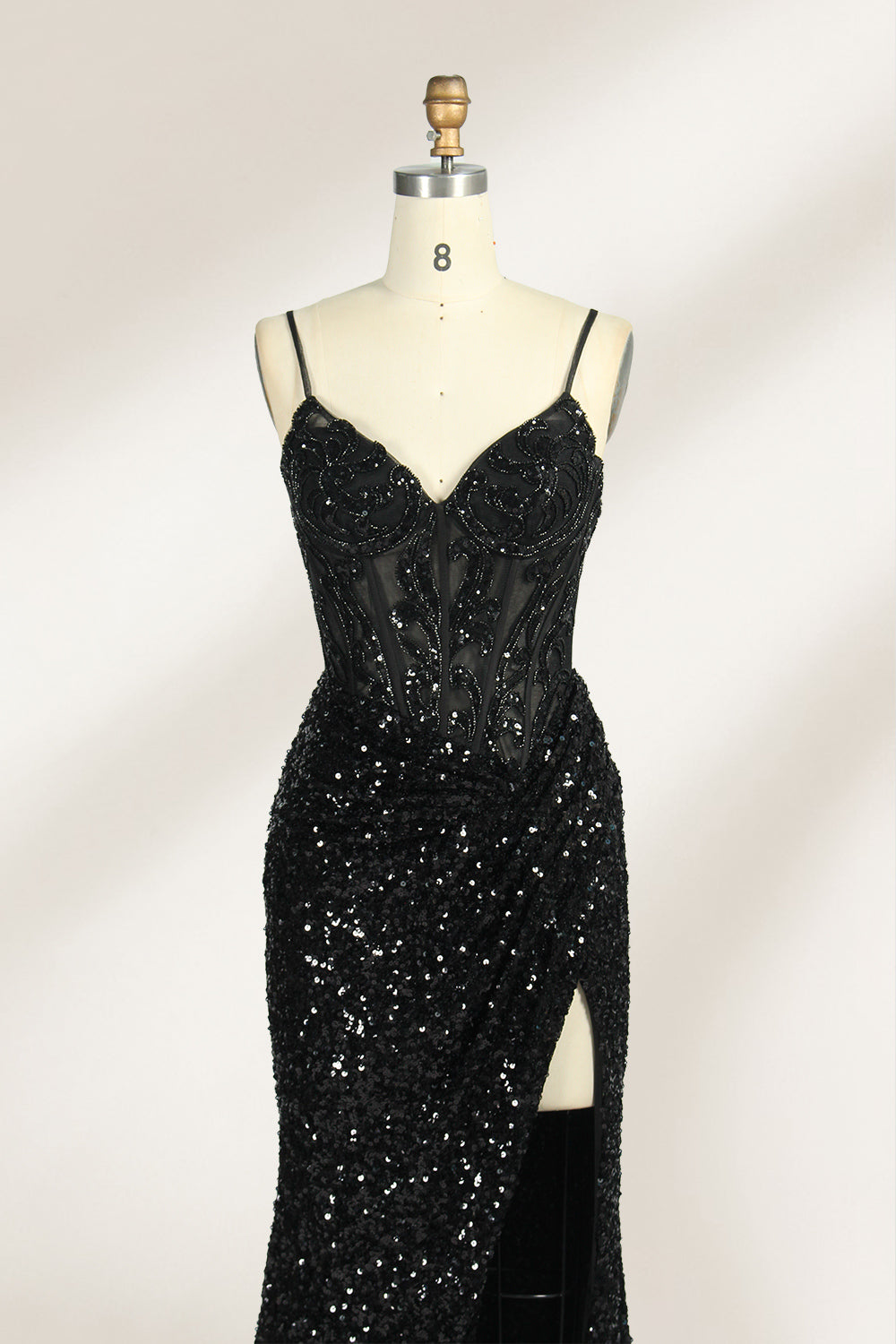 Set against a light background, a mannequin presents a blue gown adorned with sequins. It has thin straps, a deep V - neckline, and a mermaid - shaped skirt with a high side slit. The intricate sequin patterns and sheer bodice with embroidery add glamour, ideal for proms or formal dinners.3