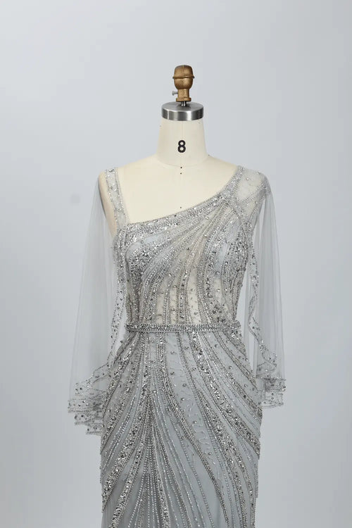 Silver draped mermaid dress with one-shoulder neckline and sheer beaded sleeves