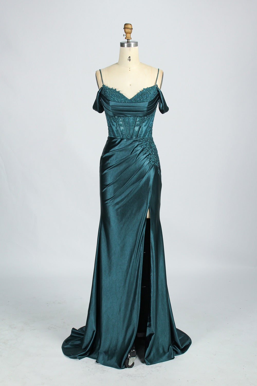 A mannequin displays a rose - gold satin gown. It has thin straps, off - shoulder lace - detailed sleeves, a ruched bodice, and a high side slit. The elegant design, blending satin and lace, suits formal events like galas or weddings.8