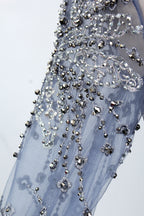 Presented on a mannequin is a blue - toned evening gown. It has a high neckline, long sheer sleeves, and intricate floral embroidery. The elegant design gives off a luxurious and sophisticated vibe, ideal for formal occasions.9
