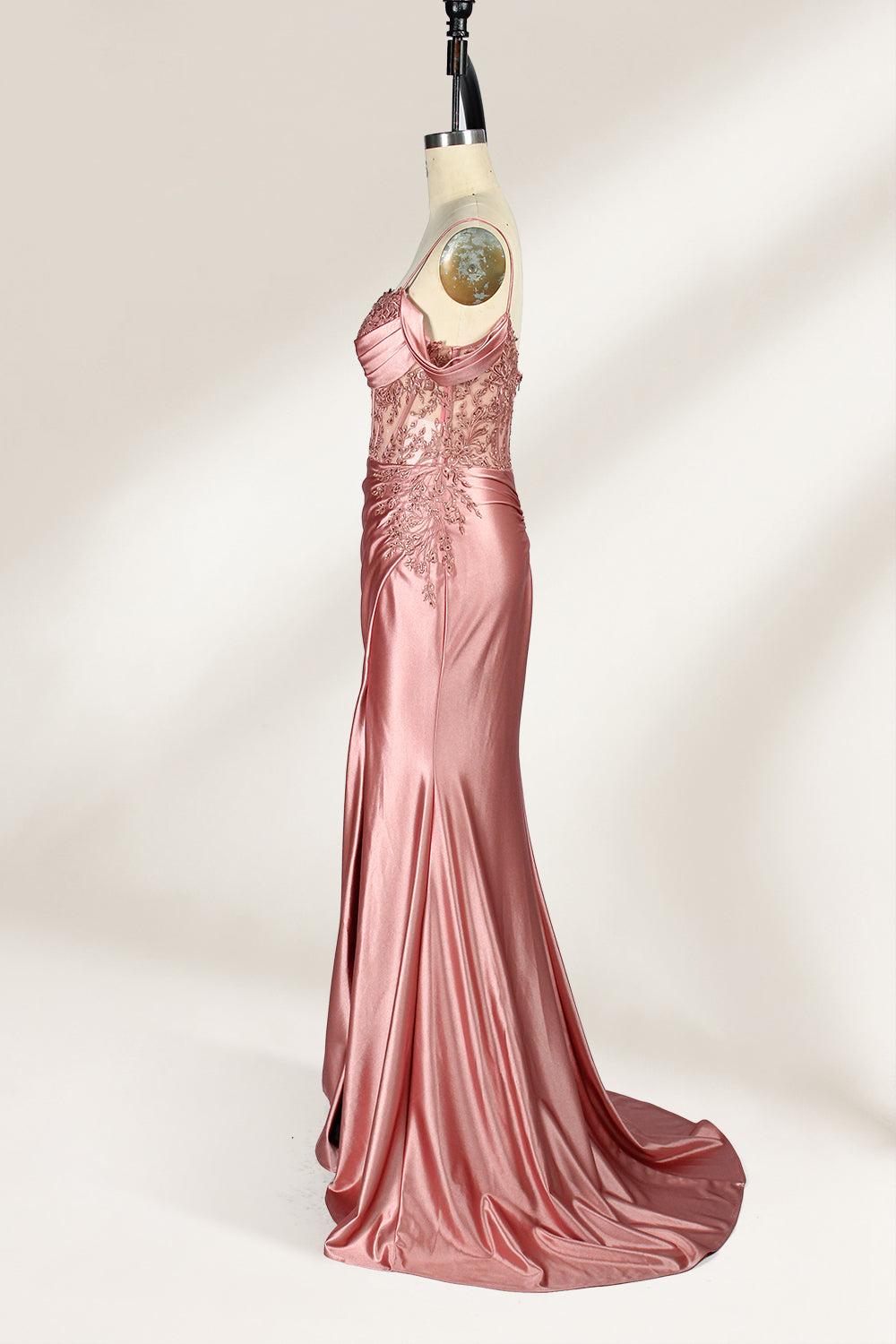A mannequin displays a rose - gold satin gown. It has thin straps, off - shoulder lace - detailed sleeves, a ruched bodice, and a high side slit. The elegant design, blending satin and lace, suits formal events like galas or weddings.7