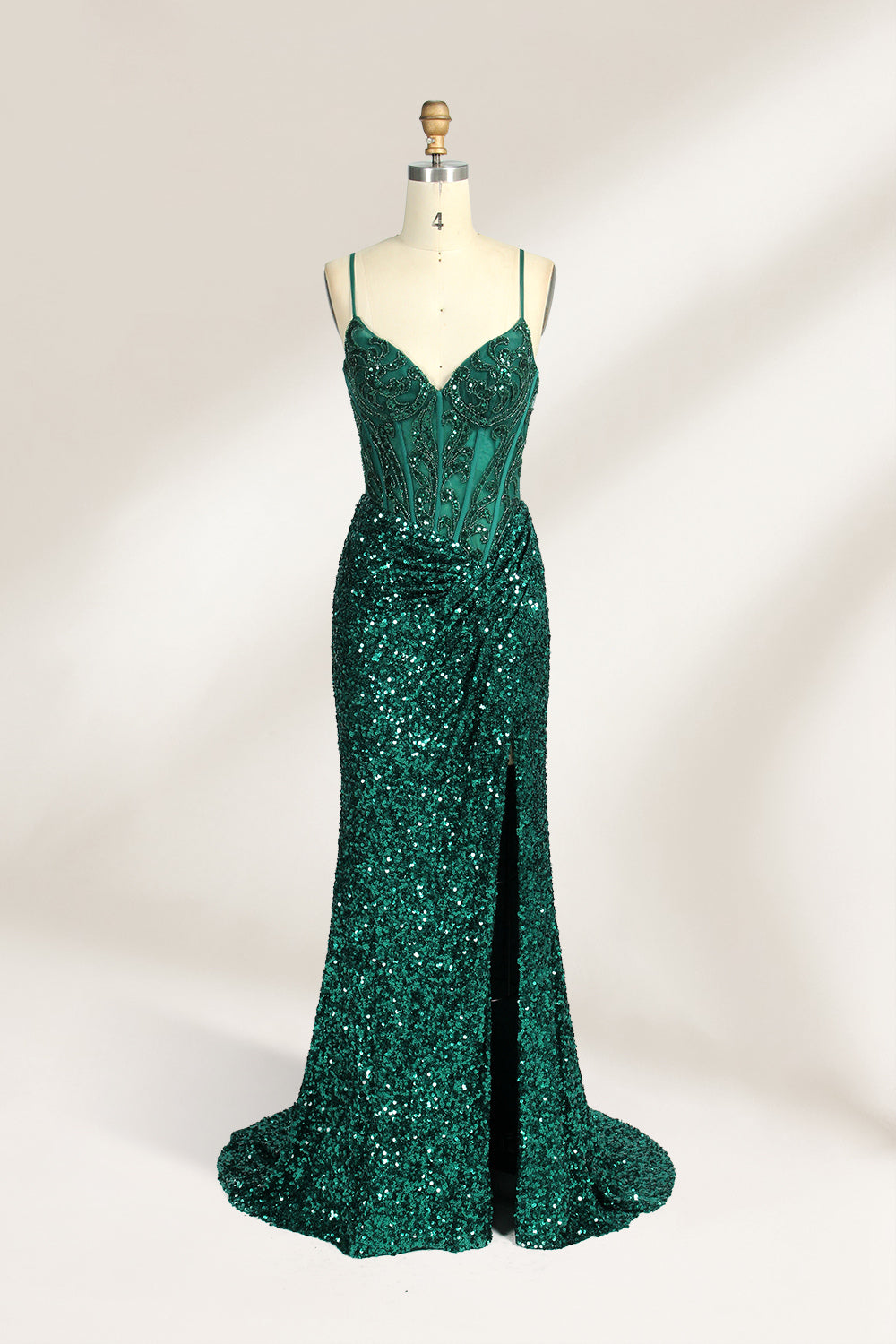 Set against a light background, a mannequin presents a blue gown adorned with sequins. It has thin straps, a deep V - neckline, and a mermaid - shaped skirt with a high side slit. The intricate sequin patterns and sheer bodice with embroidery add glamour, ideal for proms or formal dinners.5