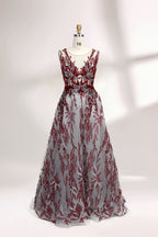 Presented on a mannequin is a gown with a gray base and rich red floral embroidery. It features a sheer neckline, a sleeveless design, and an intricate pattern that gives off a romantic and elegant vibe, perfect for formal events.1