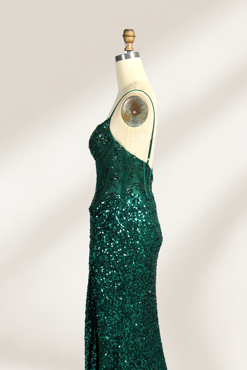 Set against a light background, a mannequin presents a blue gown adorned with sequins. It has thin straps, a deep V - neckline, and a mermaid - shaped skirt with a high side slit. The intricate sequin patterns and sheer bodice with embroidery add glamour, ideal for proms or formal dinners.6