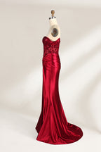 Against a light - hued backdrop, a mannequin displays a strapless red satin gown. It boasts off - shoulder ruffled sleeves, a lace - detailed bodice, and a high side slit. The ruched satin skirt and sequin - adorned top exude charm, suitable for formal dinners or galas.5