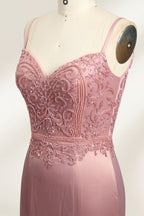 A photograph of a model mannequin wearing a floor-length, mauve satin gown with a deep V-neckline. The bodice is adorned with intricate lace detailing, featuring floral patterns and a subtle sheen. The gown has a thigh-high slit on the right side, adding a touch of elegance. The mannequin stands against a plain white background, highlighting the dress's smooth texture and elegant silhouette.04
