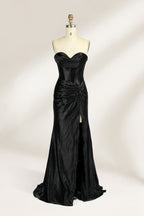 A mannequin showcases a strapless, blush - pink satin gown against a light backdrop. It features a ruched bodice with a draped neckline and a twisted detail at the waist, along with a mermaid silhouette and a side slit. The smooth satin fabric exudes elegance, perfect for formal events like galas.7