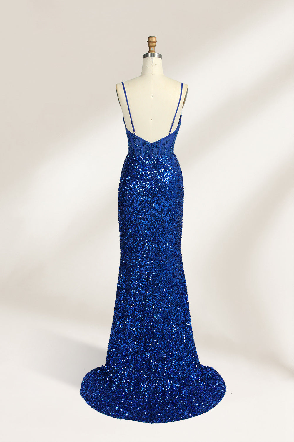 Set against a light background, a mannequin presents a blue gown adorned with sequins. It has thin straps, a deep V - neckline, and a mermaid - shaped skirt with a high side slit. The intricate sequin patterns and sheer bodice with embroidery add glamour, ideal for proms or formal dinners.2