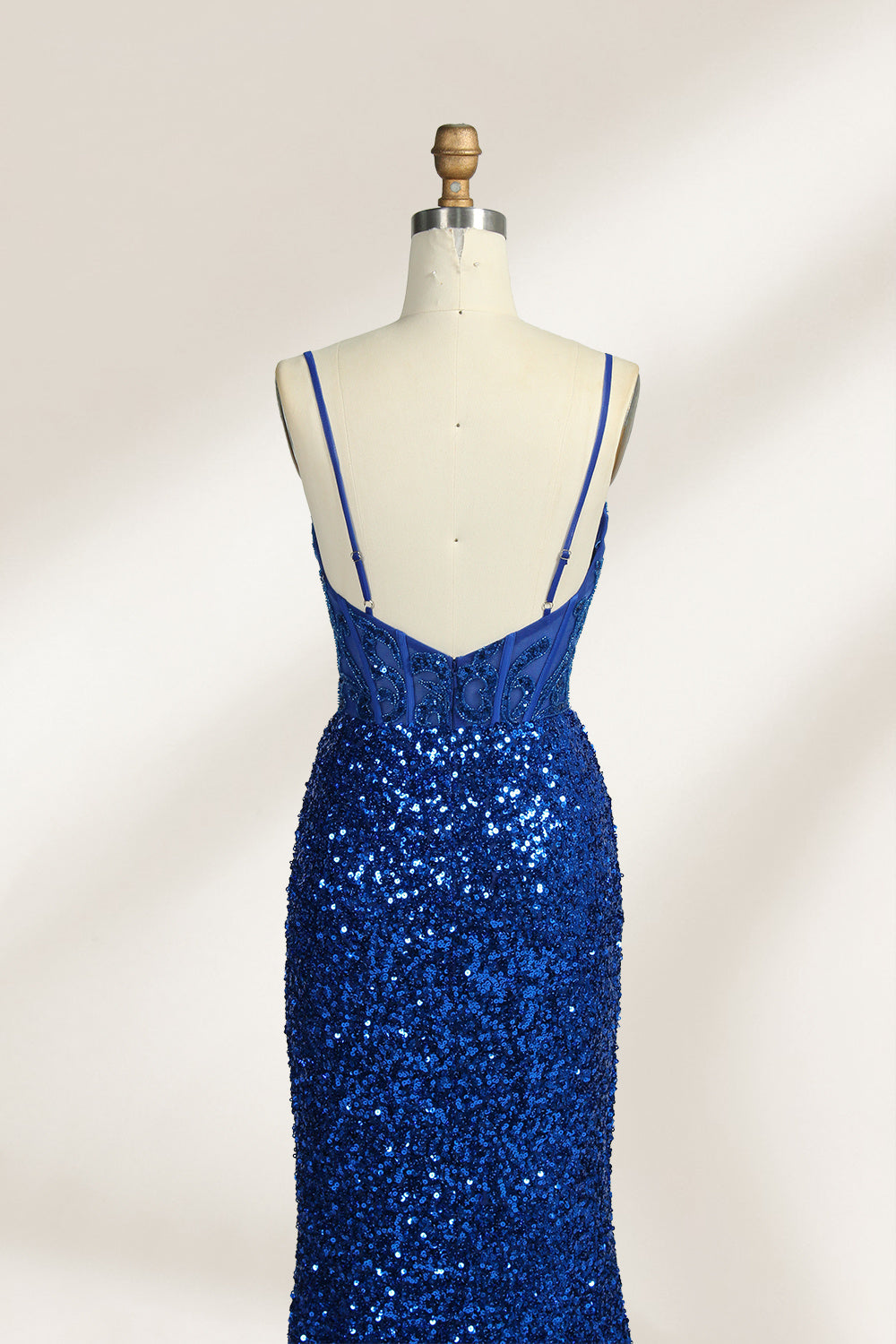 Set against a light background, a mannequin presents a blue gown adorned with sequins. It has thin straps, a deep V - neckline, and a mermaid - shaped skirt with a high side slit. The intricate sequin patterns and sheer bodice with embroidery add glamour, ideal for proms or formal dinners.4