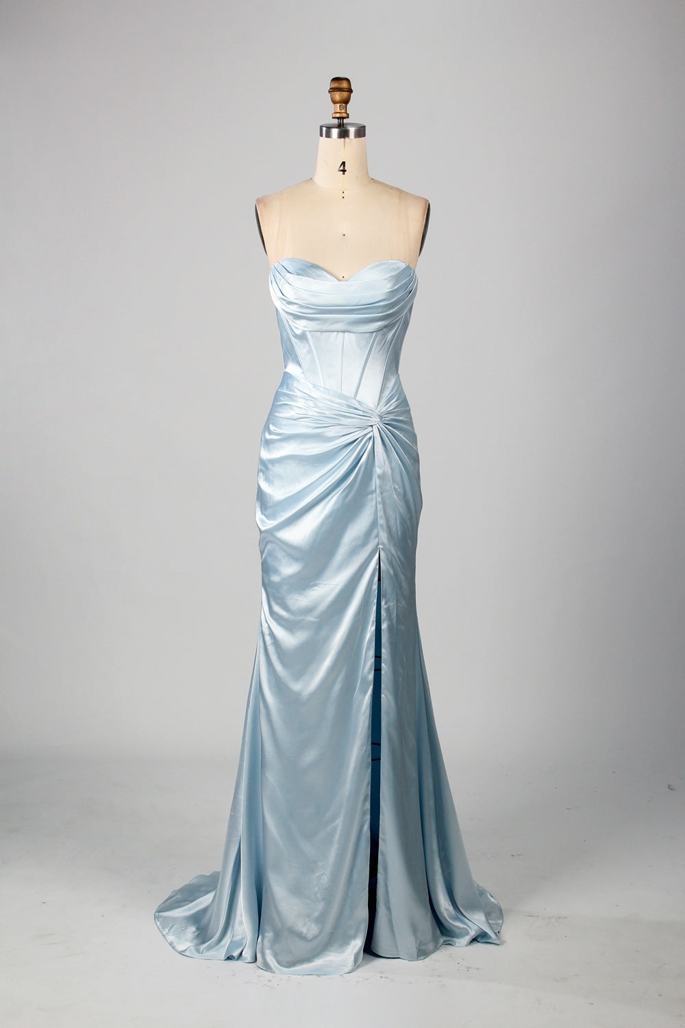 A mannequin showcases a teal satin strapless gown. It has a ruched bodice, a fitted silhouette, and a flowing, floor - length skirt with a subtle train. The elegant design, featuring gathered details, makes it suitable for formal events like galas or weddings.5