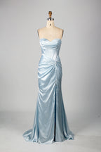 A mannequin showcases a teal satin strapless gown. It has a ruched bodice, a fitted silhouette, and a flowing, floor - length skirt with a subtle train. The elegant design, featuring gathered details, makes it suitable for formal events like galas or weddings.5