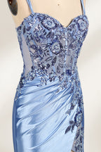 This photograph features a mannequin dressed in a luxurious, floor-length, light blue satin evening gown. The gown is intricately designed with delicate floral embroidery in silver and blue tones, primarily concentrated on the bodice and left hip. It has a plunging neckline and spaghetti straps, with a daring thigh-high slit on the left side. The mannequin is positioned against a plain, off-white background, allowing the gown's opulent texture and detailed craftsmanship to stand out. 4