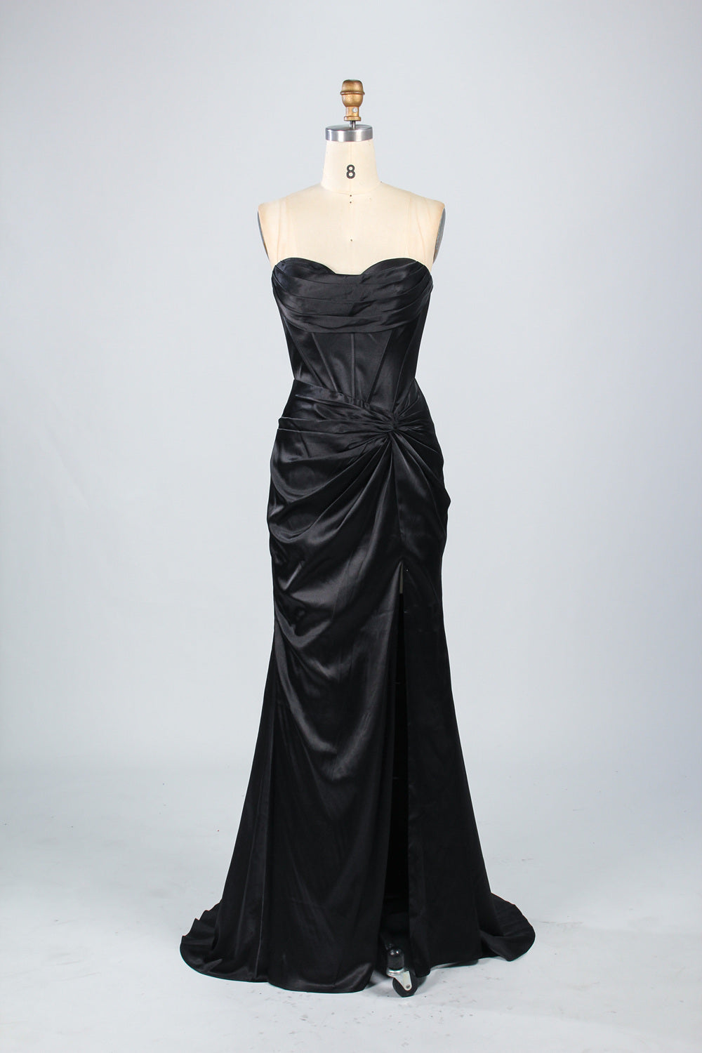 A mannequin showcases a teal satin strapless gown. It has a ruched bodice, a fitted silhouette, and a flowing, floor - length skirt with a subtle train. The elegant design, featuring gathered details, makes it suitable for formal events like galas or weddings.6