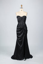 A mannequin showcases a teal satin strapless gown. It has a ruched bodice, a fitted silhouette, and a flowing, floor - length skirt with a subtle train. The elegant design, featuring gathered details, makes it suitable for formal events like galas or weddings.6