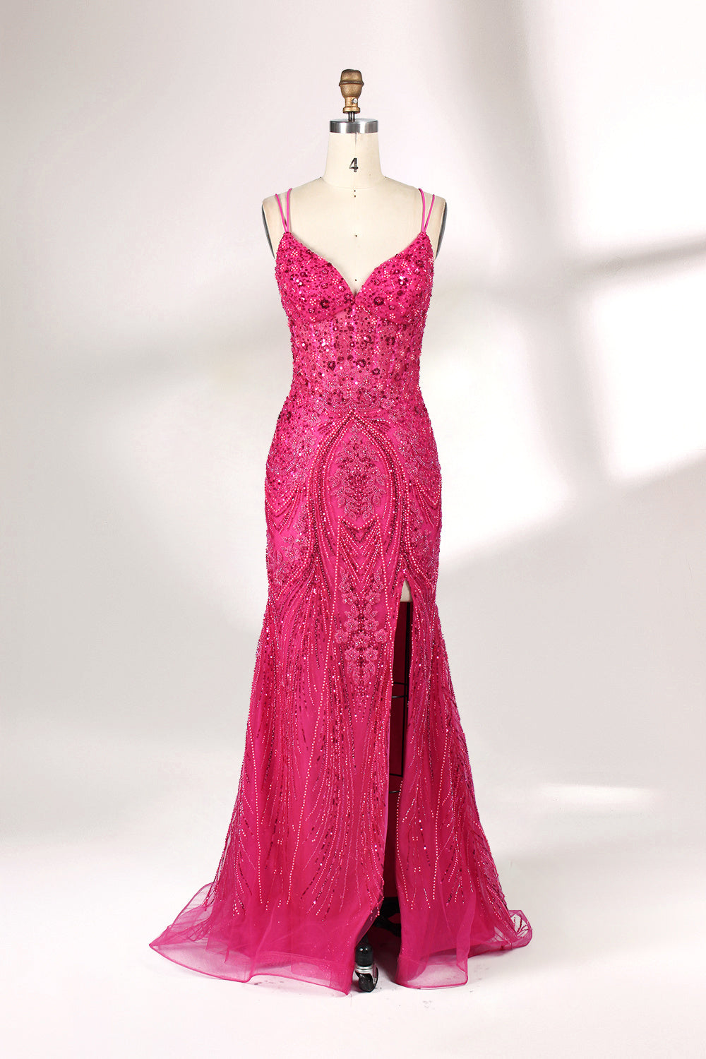 A mannequin showcases a hot - pink, fully beaded gown. It has thin straps, a deep V - neck, and a high side slit. The intricate beadwork adds glamour, making it perfect for formal events like galas or proms, radiating elegance and style.1