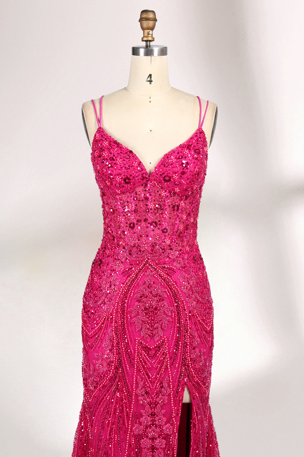 A mannequin showcases a hot - pink, fully beaded gown. It has thin straps, a deep V - neck, and a high side slit. The intricate beadwork adds glamour, making it perfect for formal events like galas or proms, radiating elegance and style.3