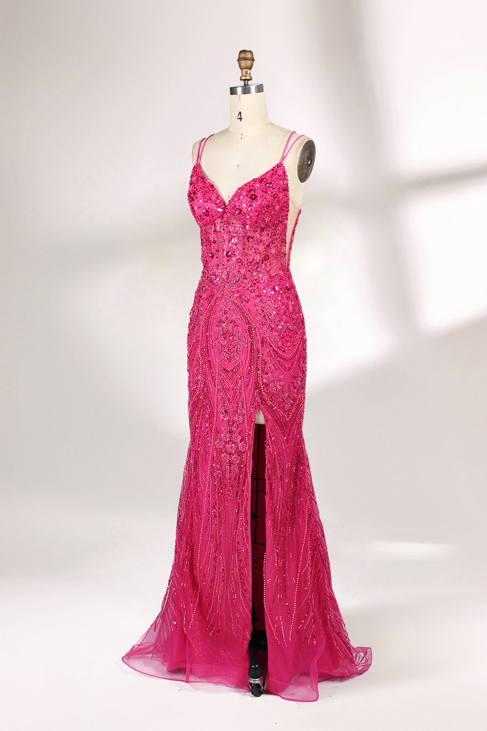 A mannequin showcases a hot - pink, fully beaded gown. It has thin straps, a deep V - neck, and a high side slit. The intricate beadwork adds glamour, making it perfect for formal events like galas or proms, radiating elegance and style.4