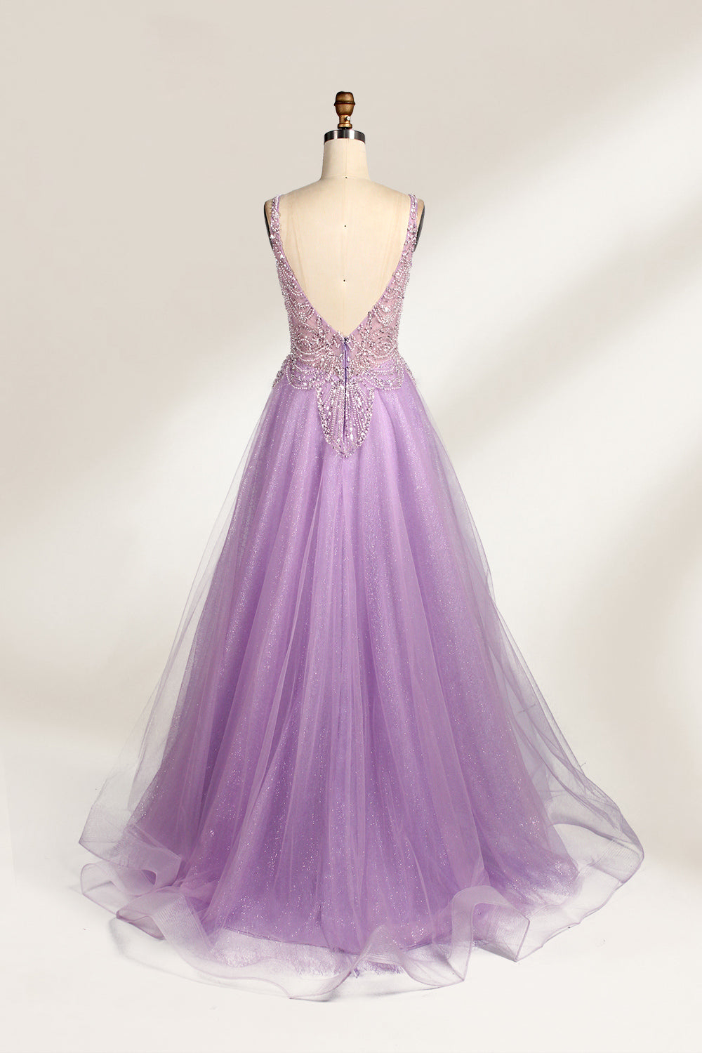 A mannequin showcases a lavender - purple tulle gown. It has a V - neck, beaded bodice, and a voluminous skirt. The elegant design, with intricate beadwork, suits formal events like galas or proms, radiating charm and grace.2