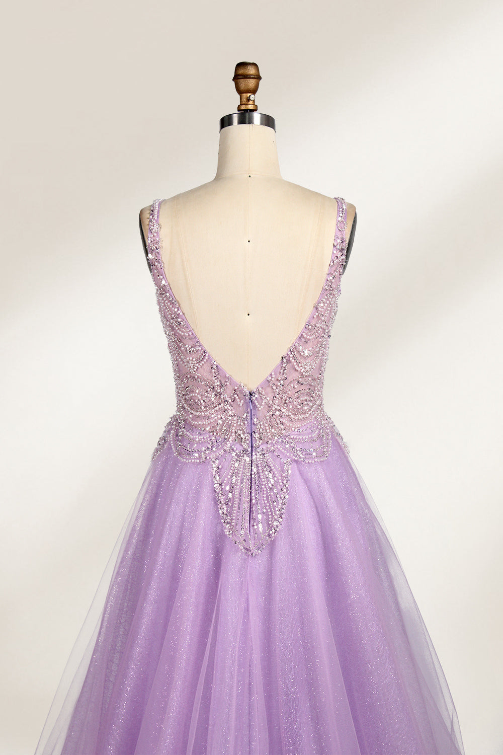 A mannequin showcases a lavender - purple tulle gown. It has a V - neck, beaded bodice, and a voluminous skirt. The elegant design, with intricate beadwork, suits formal events like galas or proms, radiating charm and grace.6