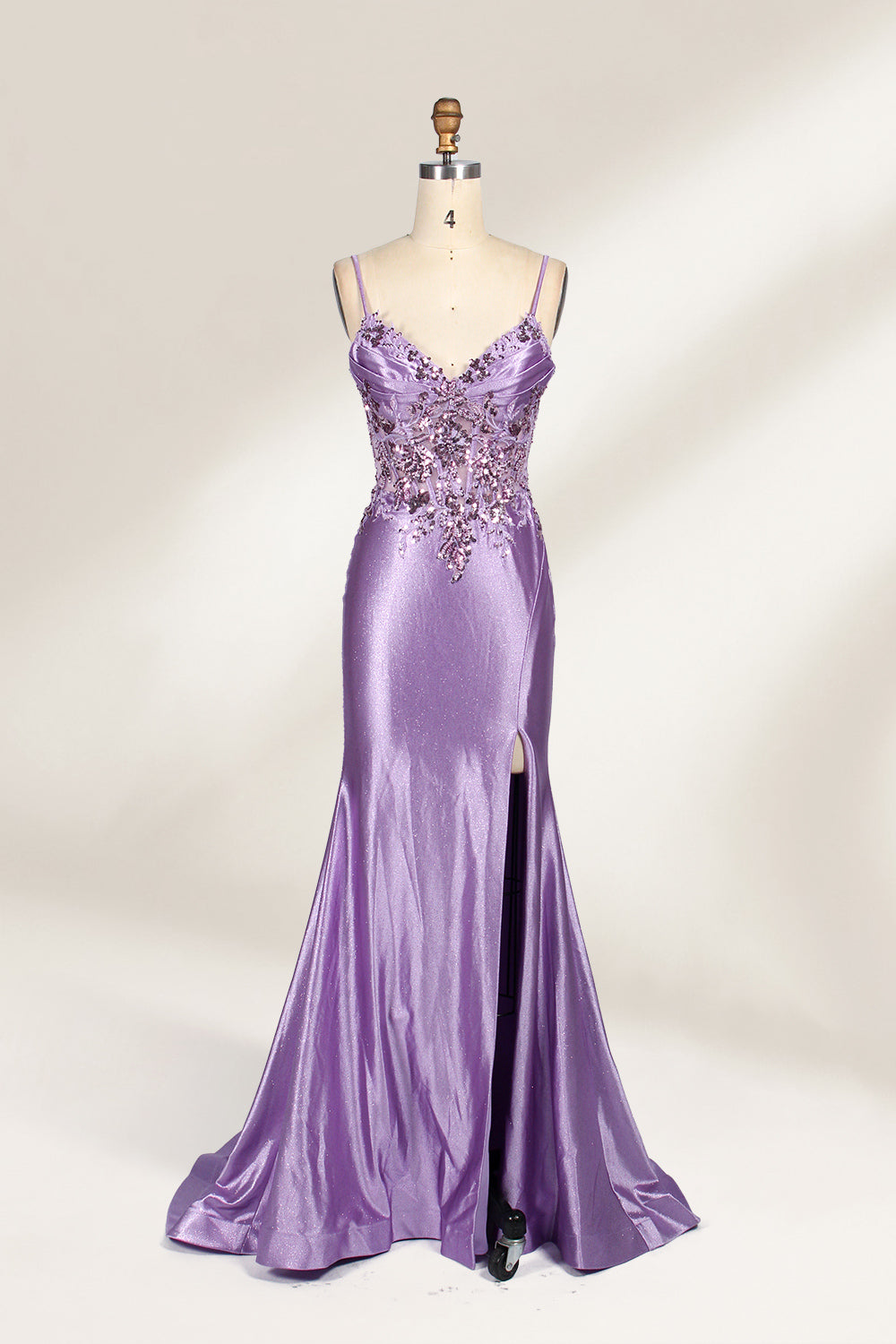 A mannequin showcases a lavender - purple satin gown. It has thin straps, a V - neck, floral - beaded bodice, and a high side slit. The elegant design, blending satin and intricate beadwork, suits formal events like galas or proms, radiating charm.1