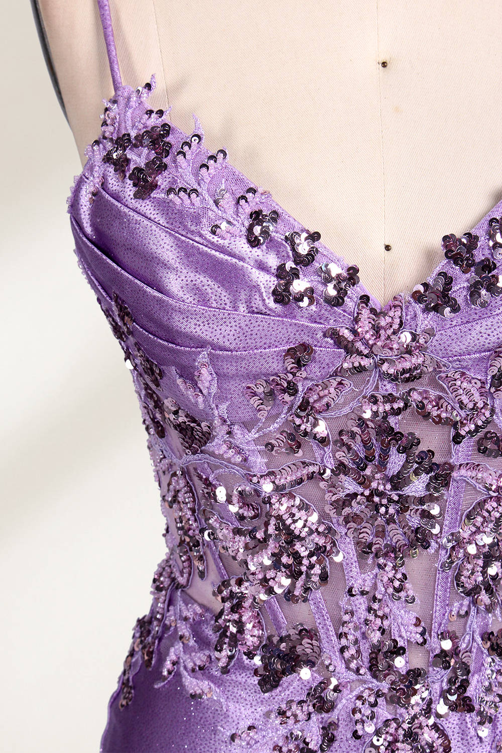 A mannequin showcases a lavender - purple satin gown. It has thin straps, a V - neck, floral - beaded bodice, and a high side slit. The elegant design, blending satin and intricate beadwork, suits formal events like galas or proms, radiating charm.4