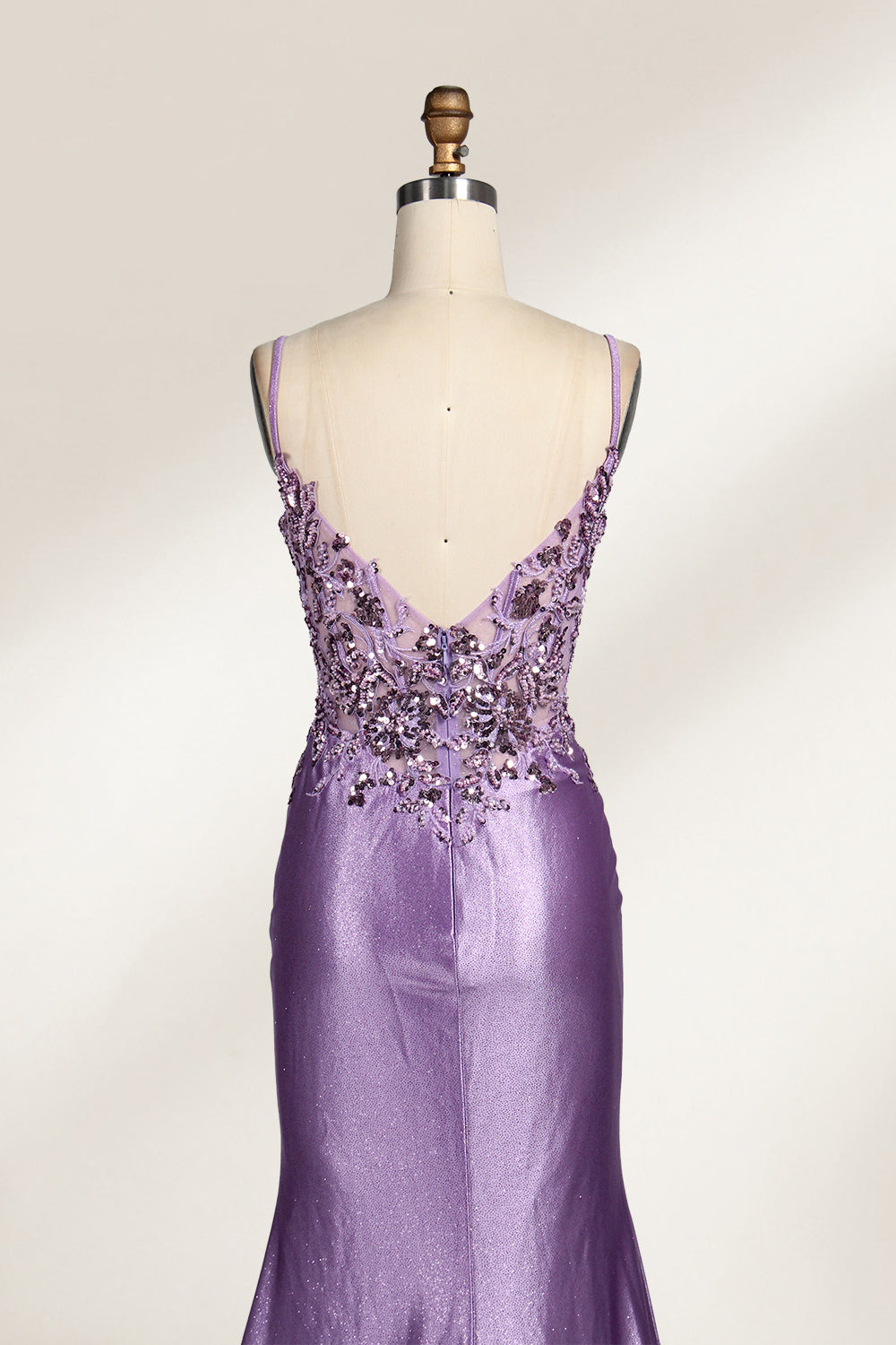 A mannequin showcases a lavender - purple satin gown. It has thin straps, a V - neck, floral - beaded bodice, and a high side slit. The elegant design, blending satin and intricate beadwork, suits formal events like galas or proms, radiating charm.6
