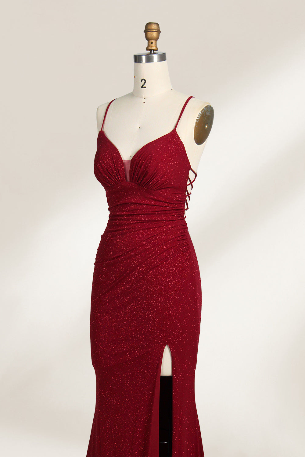 A mannequin showcases a royal - blue, glittery gown. It has thin straps, a ruched bodice, and a high side slit with a subtle train. The elegant design, with shimmering fabric, suits formal events like galas or proms, radiating sophistication.5
